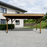 Doppelcarport Amecke aus Holz mit Holzblende auf einer breiten gepflasterten Einfahrt vor einem Einfamilienhaus