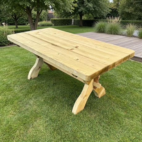 Gartenholz.org Hennetal solid softwood garden table with a natural finish, featuring a sturdy trestle base on grass.